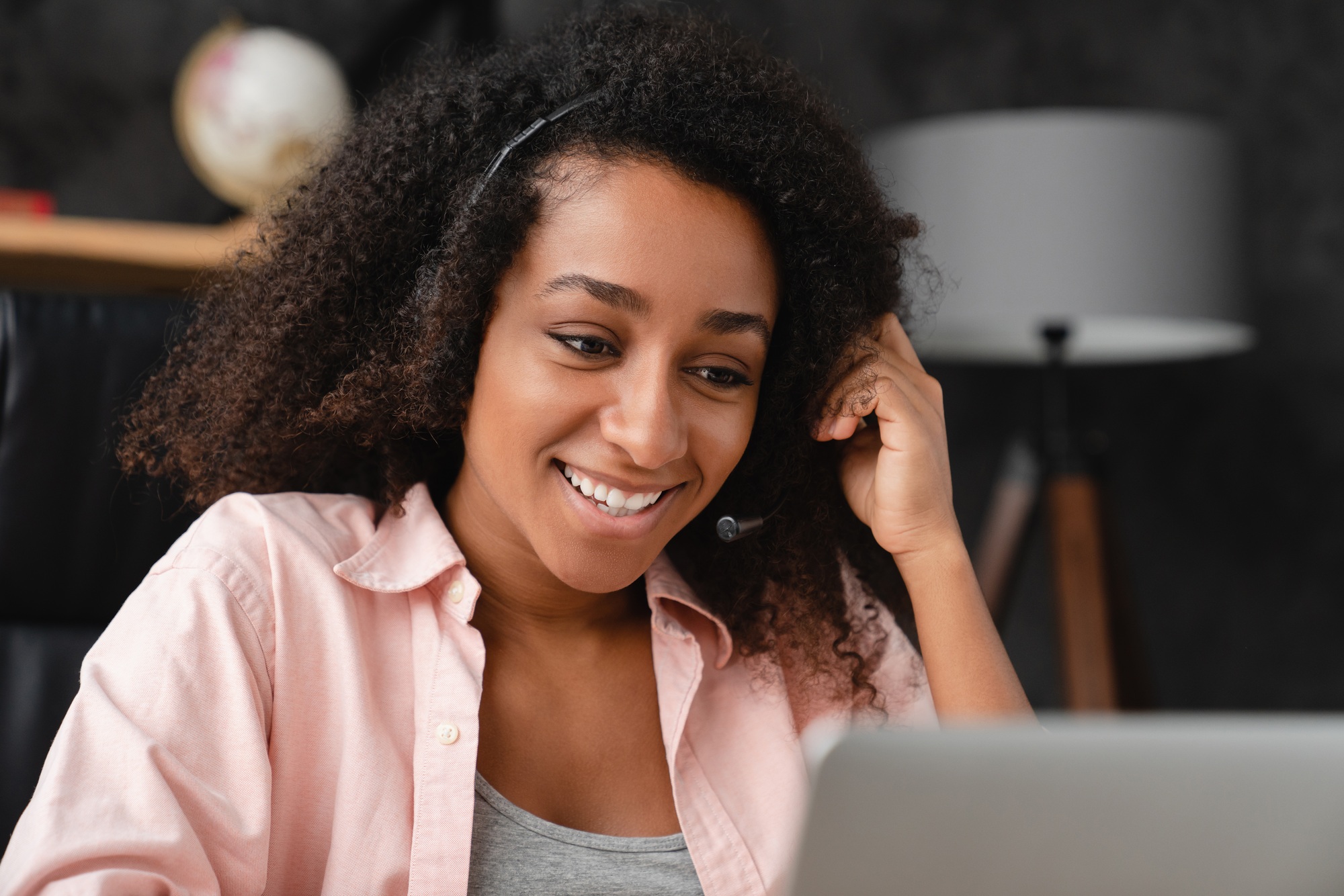 IT support customer support manager in headset using laptop, working remotely, having videocall